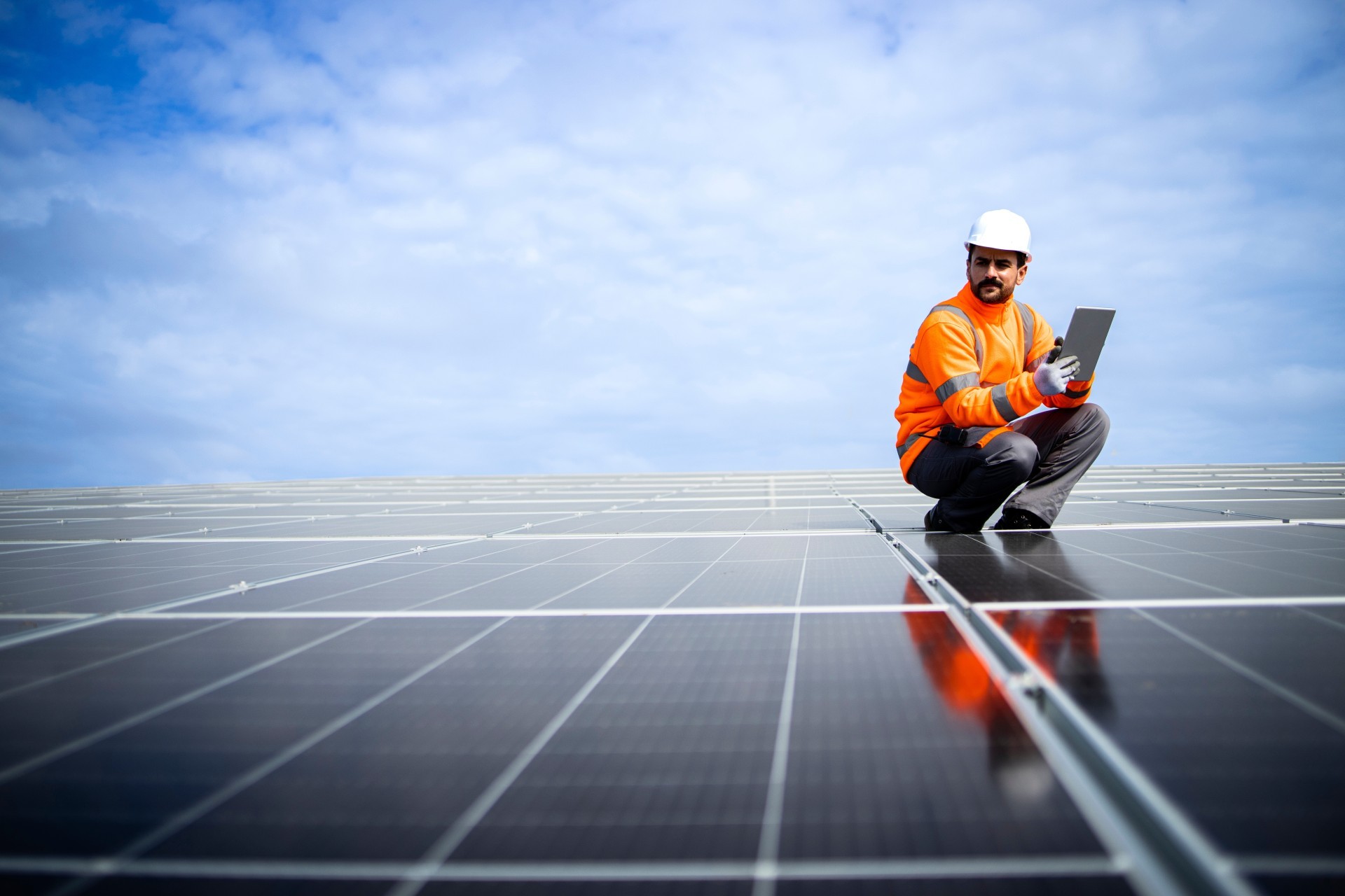 Man zit met tablet op zonnepanelen