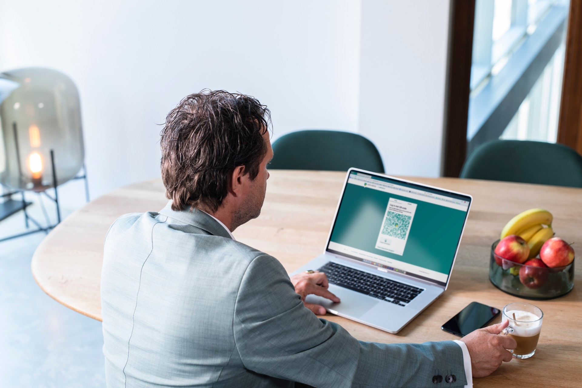 Man kijkt naar zijn laptopscherm met daarop een twijfelachtige QR-code