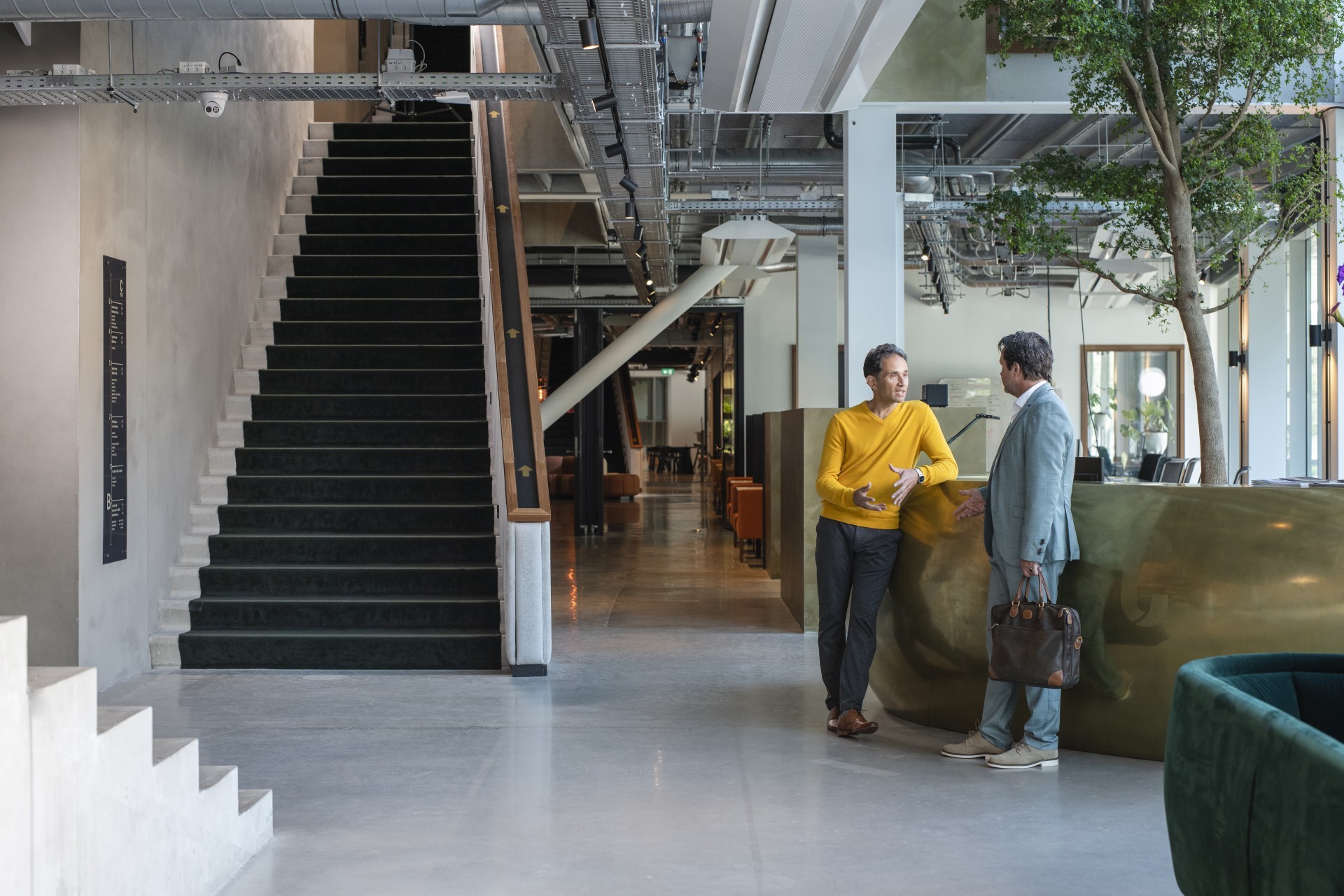 Man in pak praat met een collega