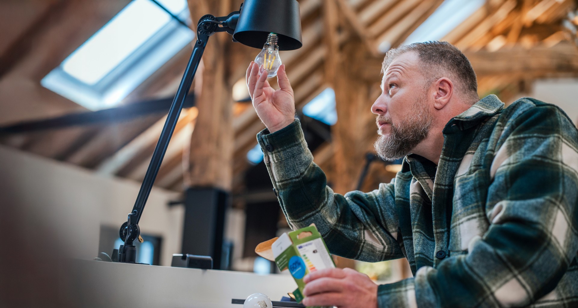 Man bekijkt gloeilamp in lamp