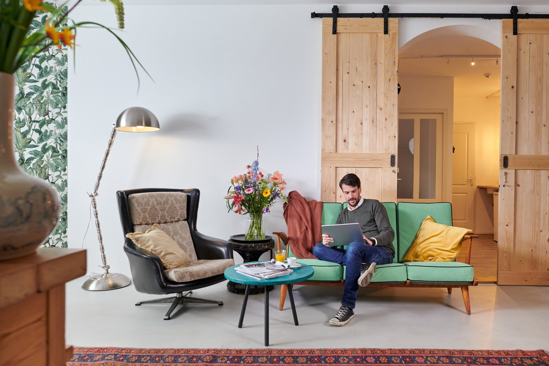 Man zit comfortabel op bank en kijkt naar het scherm van zijn laptop